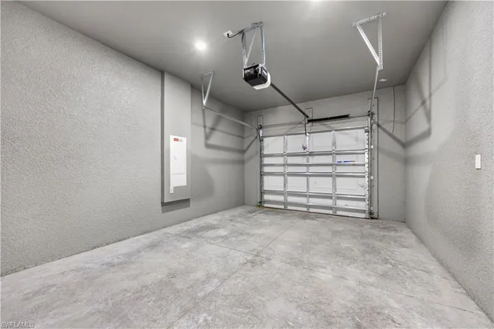 Garage featuring a textured wall and a garage door opener