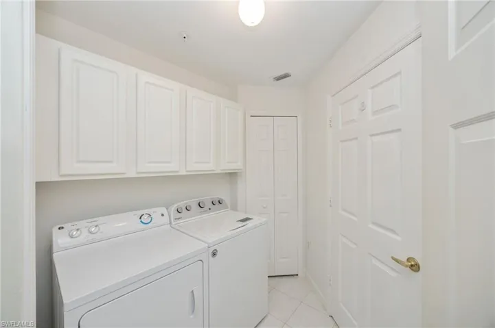 Separate laundry room with upper cabinets