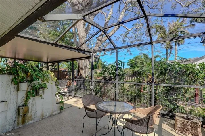 View of patio with a lanai and fence