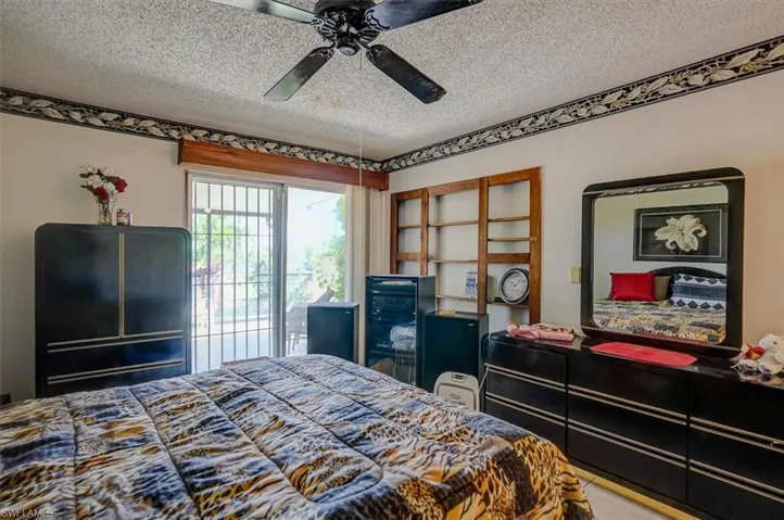 Bedroom with a ceiling fan and a textured ceiling