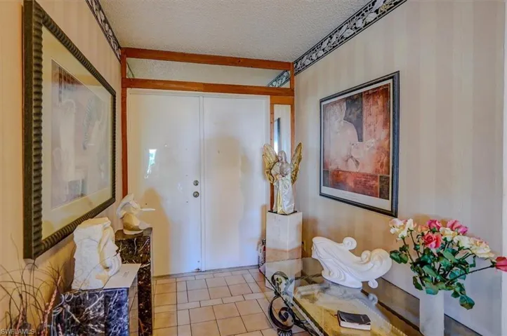 Foyer entrance featuring a textured ceiling and light tile patterned floors