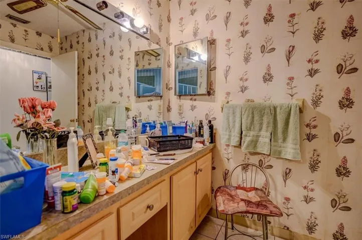 Bathroom featuring a ceiling fan, tile patterned flooring, vanity, and wallpapered walls