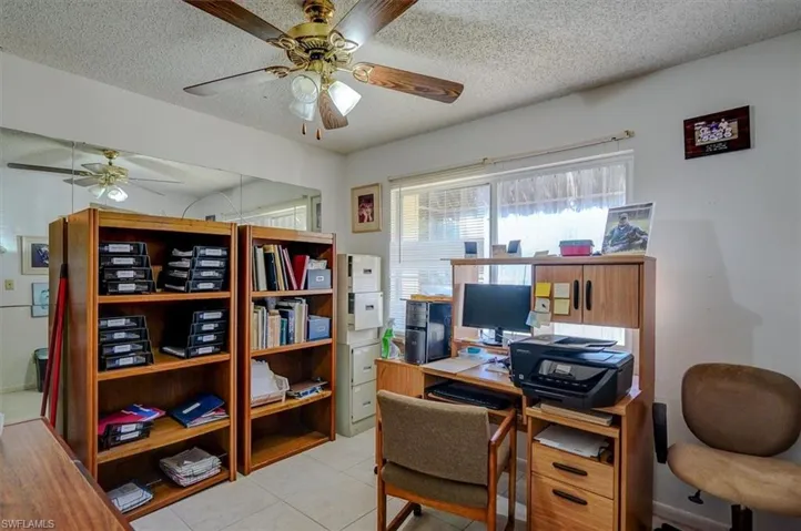 Office featuring a textured ceiling, light tile patterned floors, and a ceiling fan