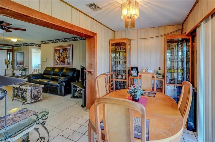 Dining space featuring a ceiling fan, visible vents, crown molding, and light tile patterned flooring