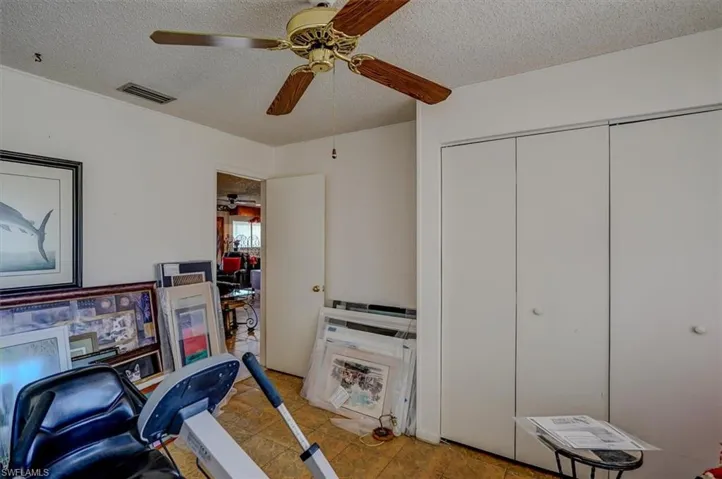 Office with a ceiling fan, visible vents, a textured ceiling, and light tile patterned floors