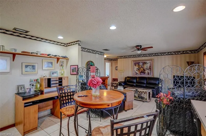 Dining space with ceiling fan, visible vents, a textured ceiling, and light tile patterned flooring