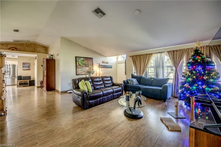 Vaulted ceilings, wood-finish tile flooring, and arched windows