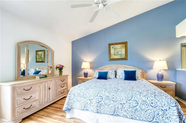Bedroom with light wood finished floors, vaulted ceiling, and ceiling fan