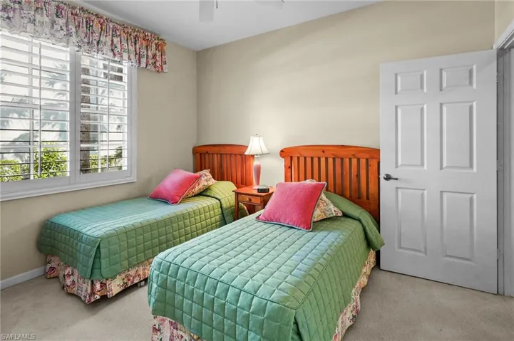 Carpeted bedroom with a ceiling fan