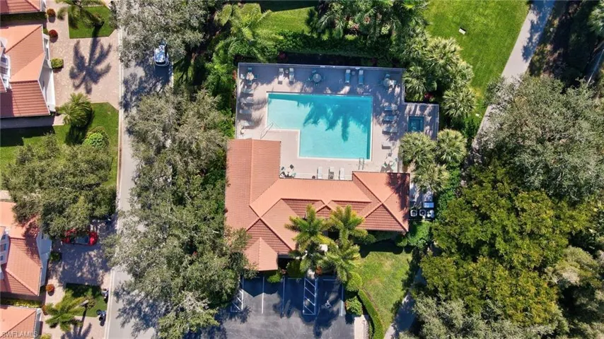 Drone / aerial view of a pool area and a tree filled landscape