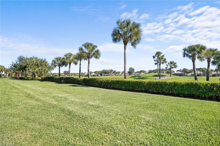 View of home's community with a lawn and view of golf course