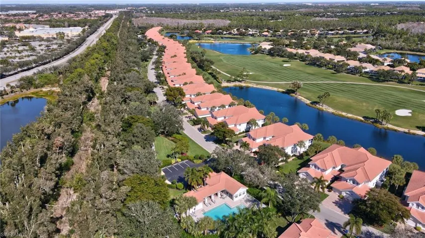 Aerial perspective of suburban area featuring a large body of water and a golf course