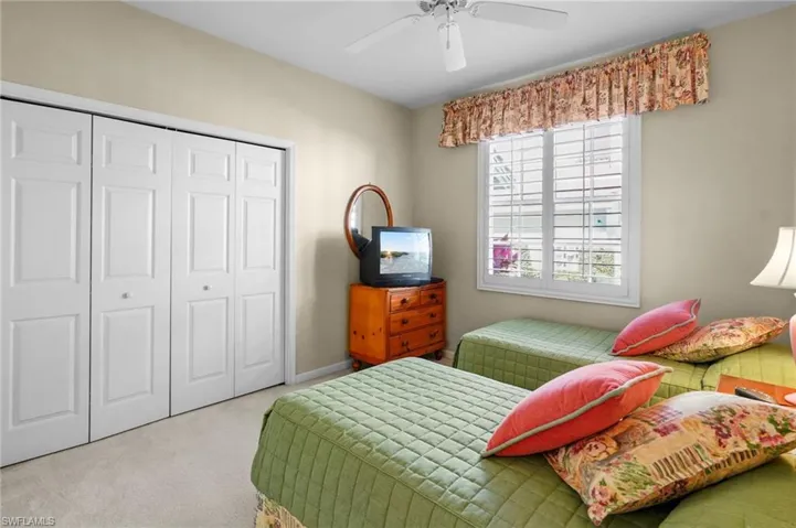 Bedroom with carpet, a closet, and a ceiling fan
