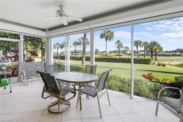 Sunroom with tile patterned floors and view of golf course