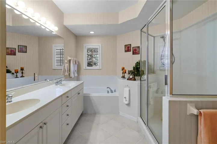 Bathroom featuring wallpapered walls, double vanity, a bath, a stall shower, and recessed lighting