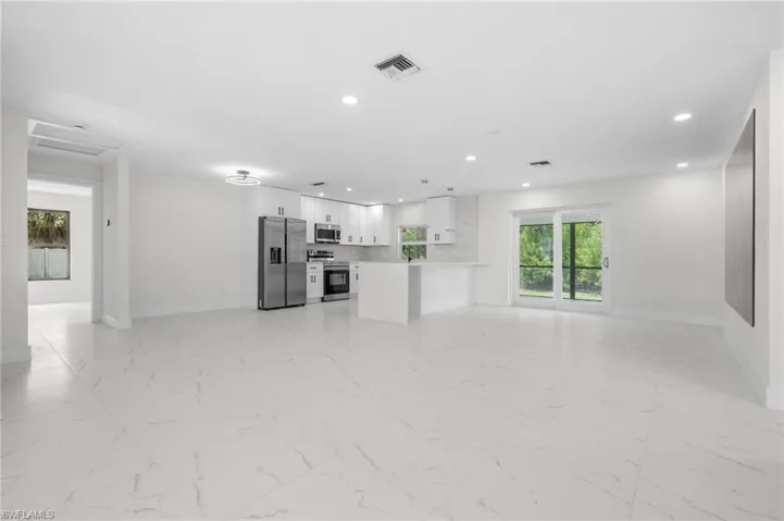 Unfurnished living room with light marble finish flooring and recessed lighting