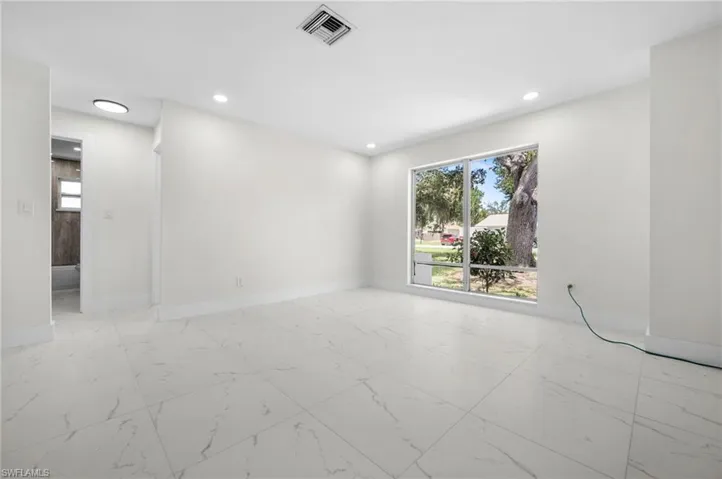 Unfurnished room featuring light marble finish floors, recessed lighting, and plenty of natural light