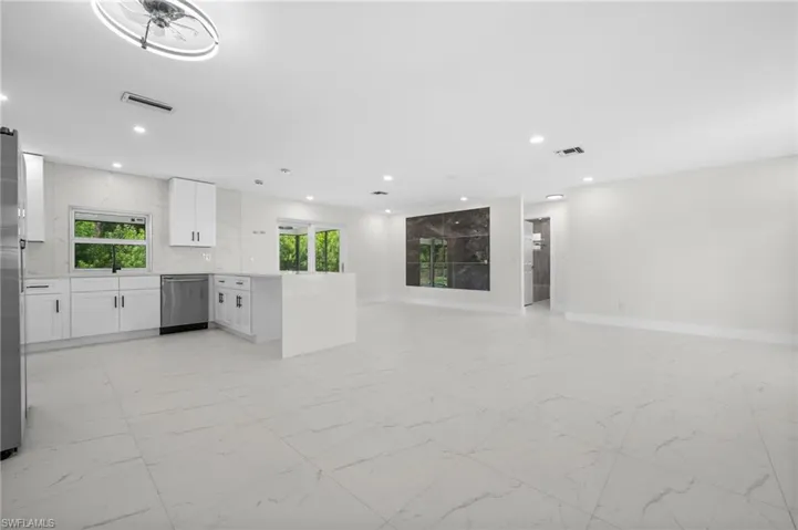 Unfurnished living room featuring light marble finish flooring and recessed lighting