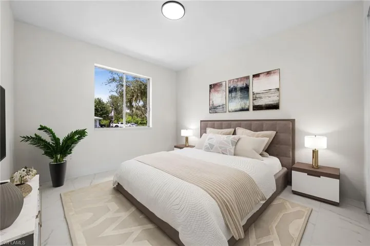 Bedroom featuring marble look tile flooring and baseboards