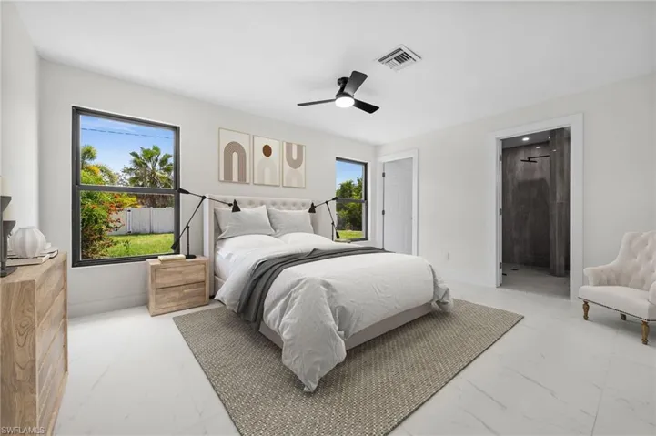 Bedroom with marble finish flooring, ceiling fan, and connected bathroom