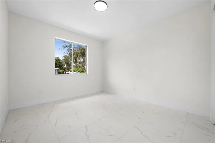 Empty room featuring light marble finish floors and baseboards