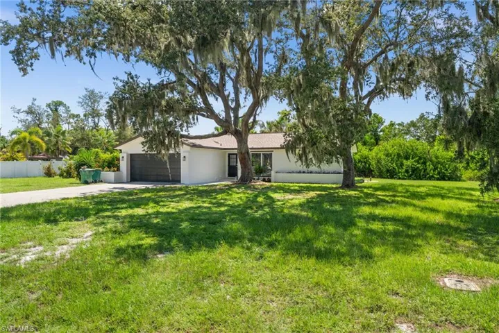 Single story home with a garage, driveway, and stucco siding