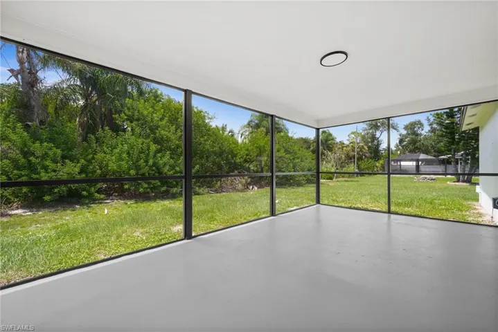 Unfurnished sunroom with view of wooded area
