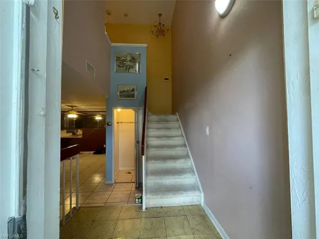 Two-story entry with a carpeted staircase and tile flooring