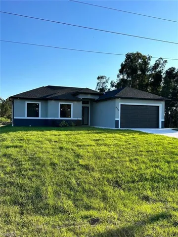 Single story home with a garage, a front yard, and stucco siding