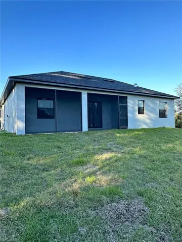 Rear view of house featuring a lawn