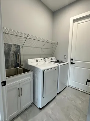Laundry featuring a sink with washing machine and dryer