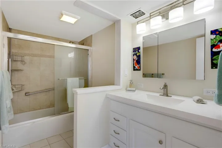 Primary en suite with custom tiled shower, tub, glass doors, and new vanity, lighting & plumbing fixtures!