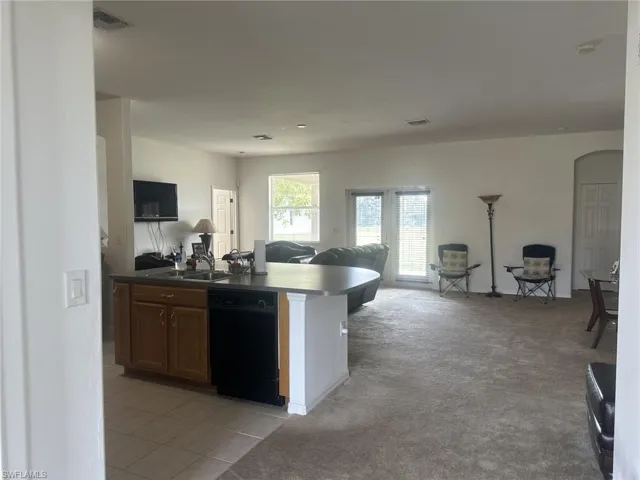 Kitchen with dishwasher, sink, and family room.