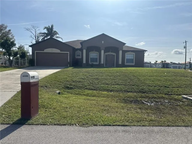 View of front of house featuring a garage and a front yard