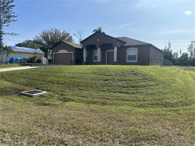 Ranch-style house with a garage and a front yard