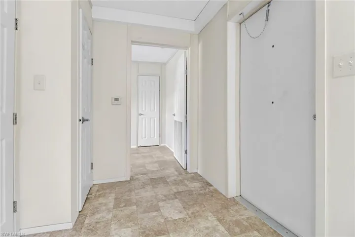 Corridor featuring light tile floors