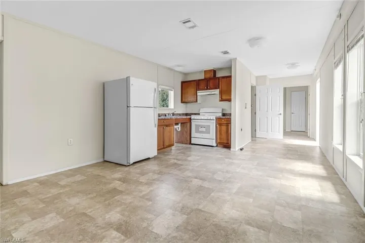 Kitchen featuring white appliances and light tile floors