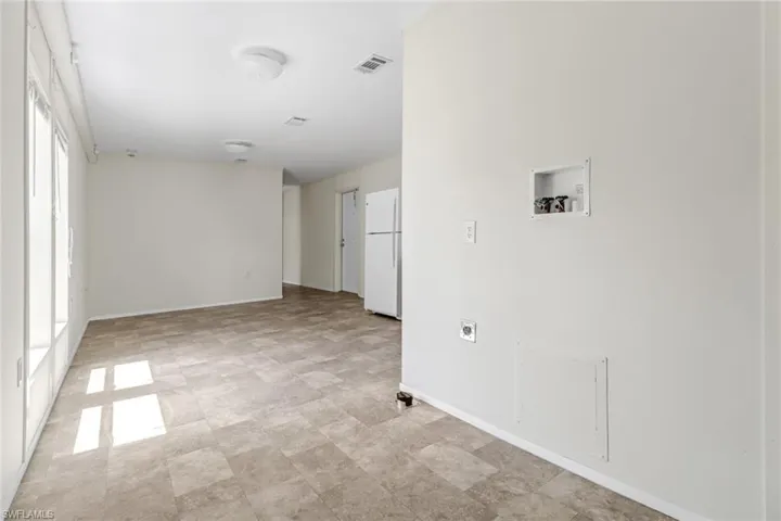 Tiled spare room featuring a healthy amount of sunlight