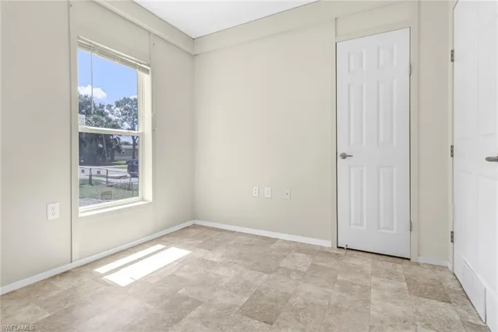 Unfurnished bedroom with light tile flooring and multiple windows