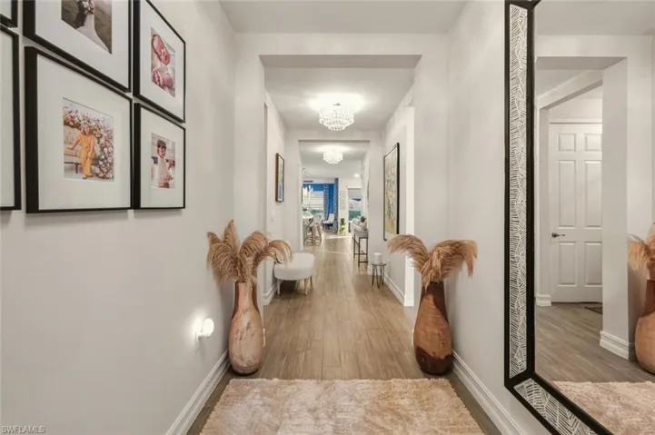 Hall with a chandelier and wood finished floors