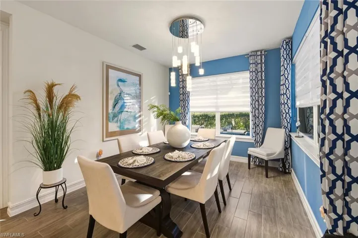 Dining space featuring wood tiled floors and a chandelier