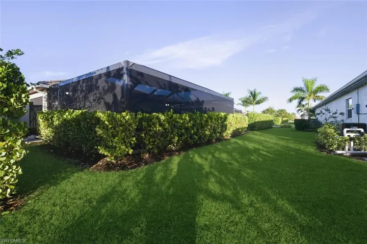 View of green lawn featuring glass enclosure