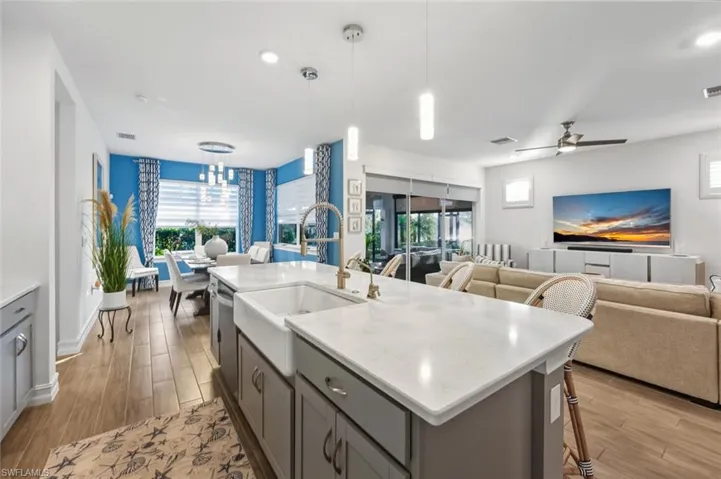 Kitchen with gray cabinets, pendant lighting, a breakfast bar area, light wood-style flooring, and recessed lighting