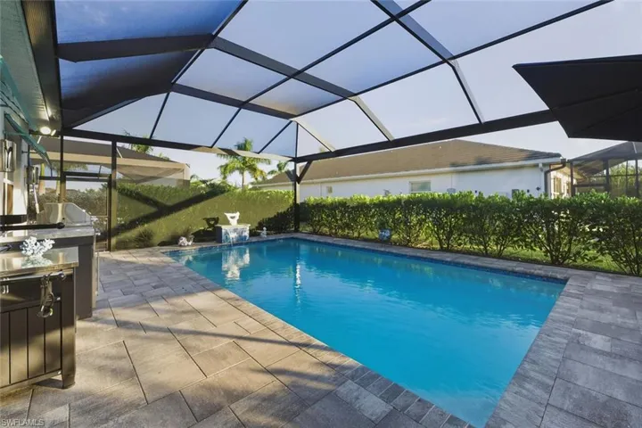 Outdoor pool featuring a sunroom, a lanai, and a patio area