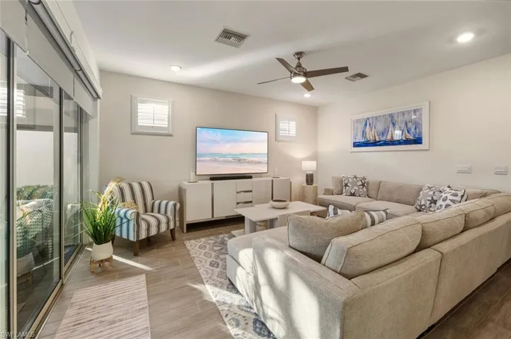Living area featuring wood tiled floors, a ceiling fan, and recessed lighting