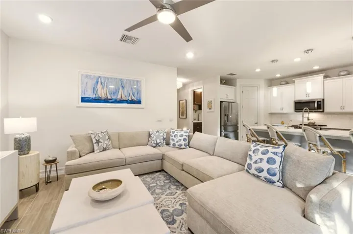 Living area with wood finish floors, recessed lighting, and a ceiling fan