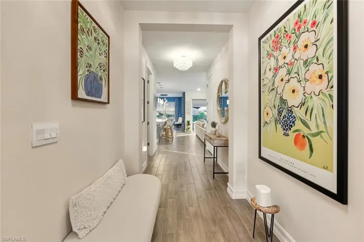 Corridor featuring wood finish floors and a chandelier