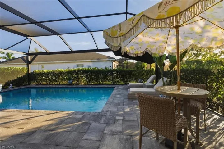 View of swimming pool featuring a patio, a sunroom, and glass enclosure