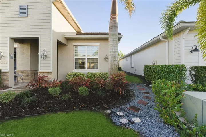 View of property exterior featuring stone siding, stucco siding, and a yard