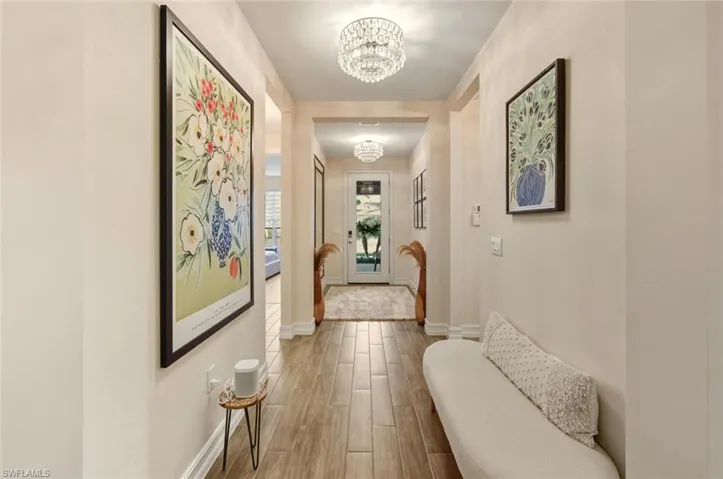 Corridor featuring a chandelier and wood finish floors